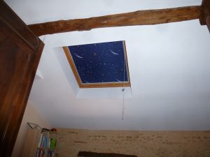 [:fr]Fenêtre de toiture Velux confort GGl 114x118 avec store d'occultation ciel étoilé[:en]Skylight 'Velux confort GGL' 114x118 with star pattern roller blind[:]